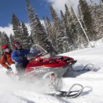 Two people snowmobiling in Big Sky.